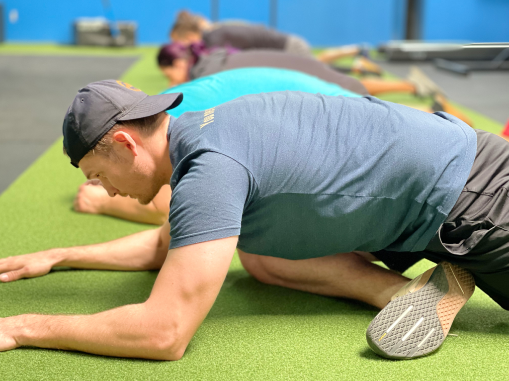 Man stretches over athletic turf artificial turf.